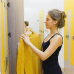 Woman holding a yellow sweater at a locker